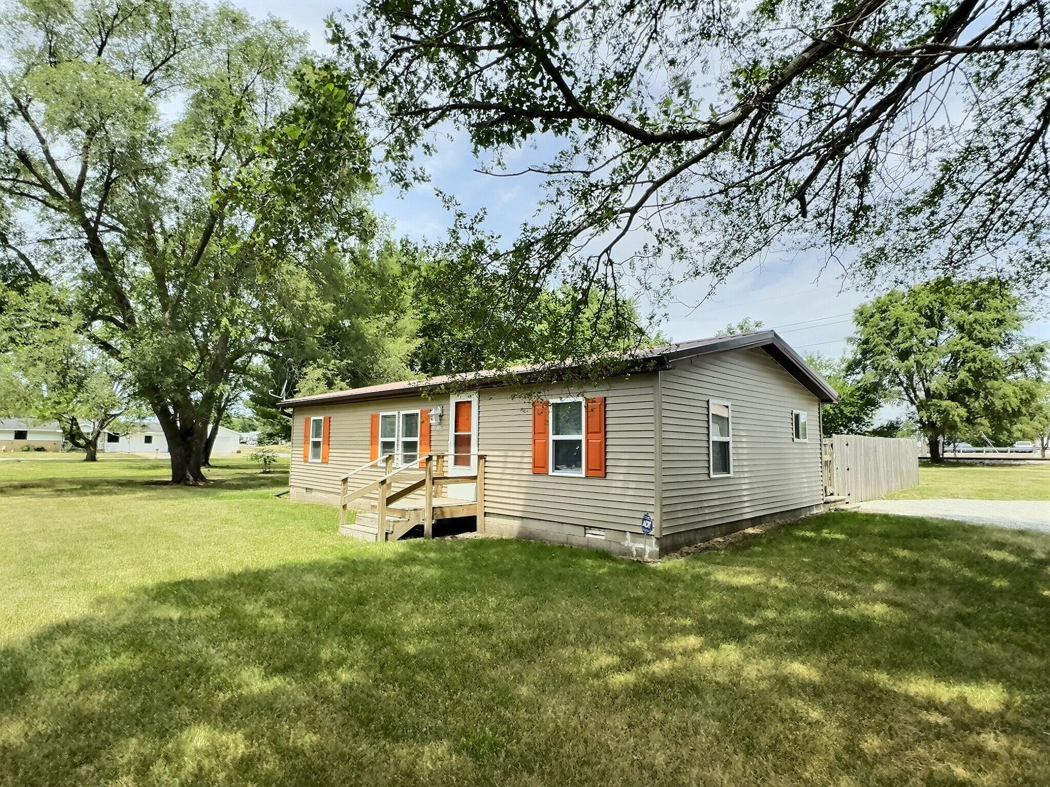 a view of a yard with a house and a large tree