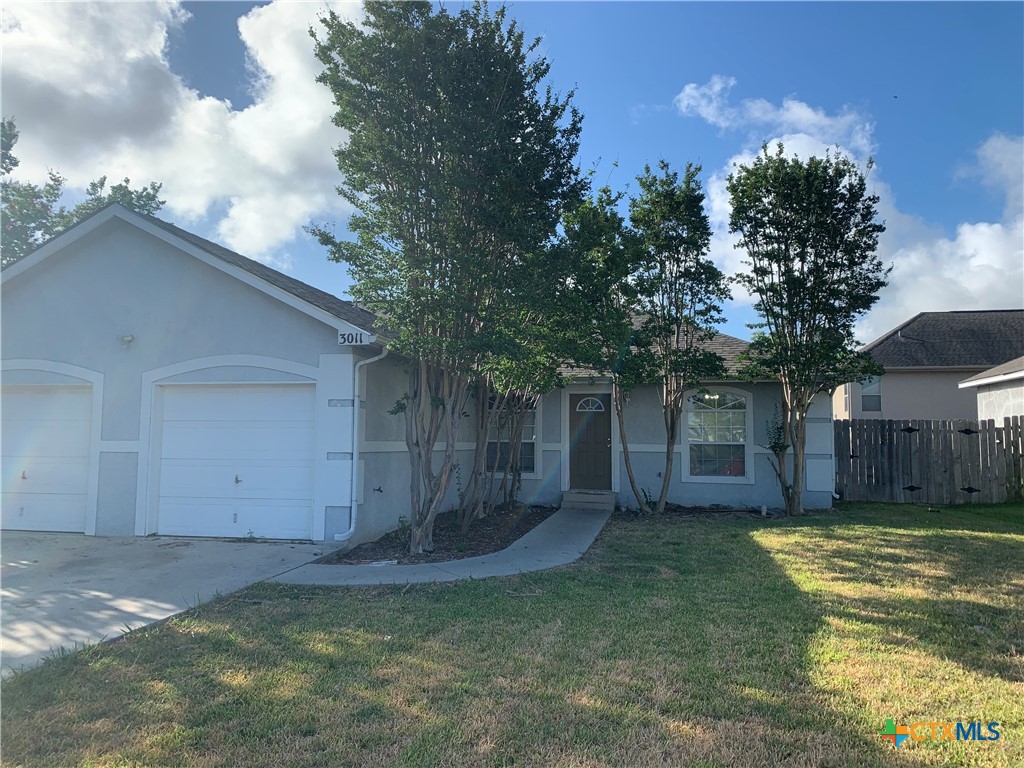 a view of a house with a yard garage and tree