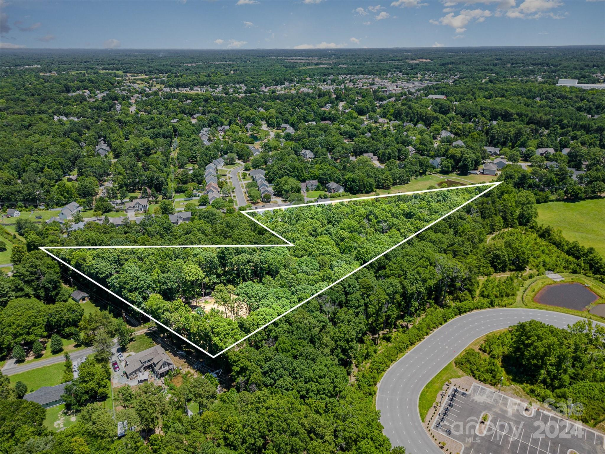 an aerial view of a residential houses with outdoor space and trees