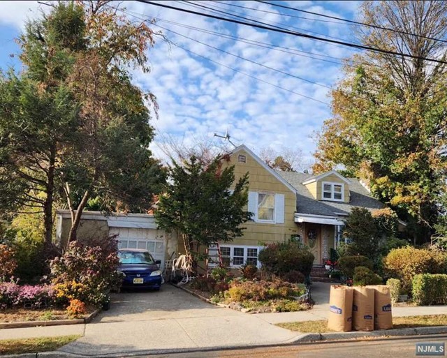 a front view of a house with yard and parking