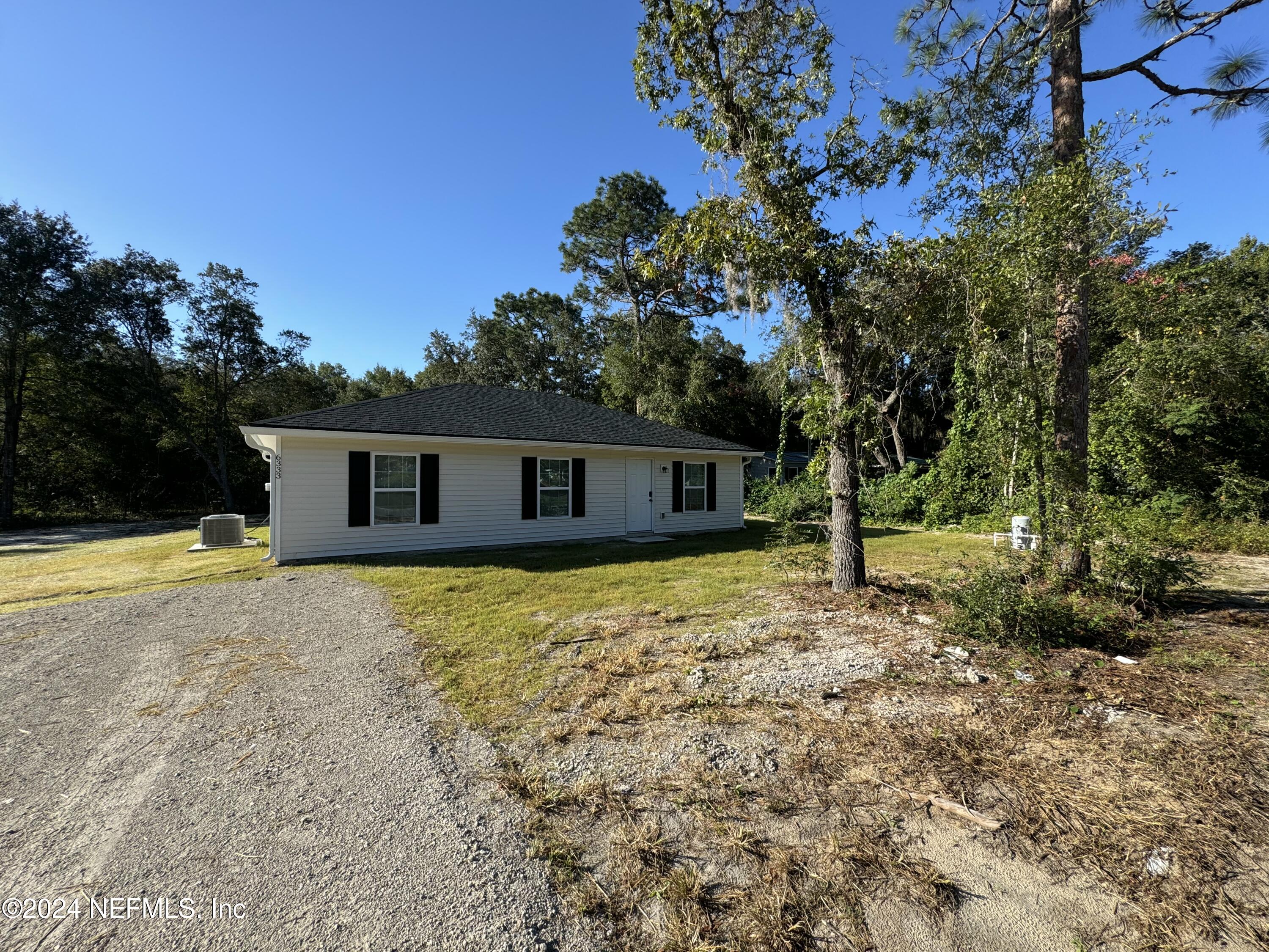 a front view of house with yard and trees