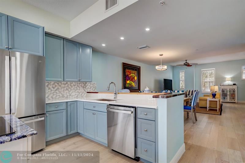 a kitchen with a sink a stove a refrigerator and chairs