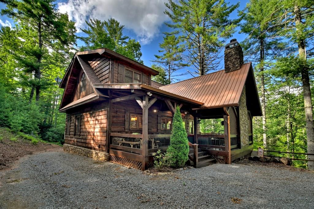 a view of a house with a yard and large trees