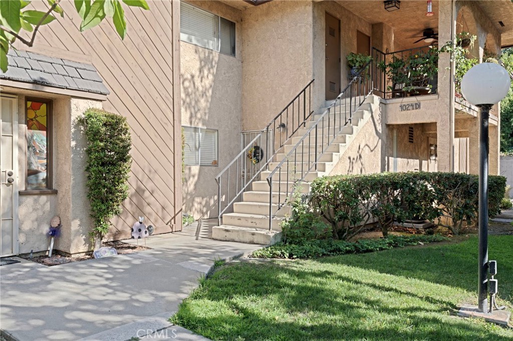 a view of a brick house with a yard and plants