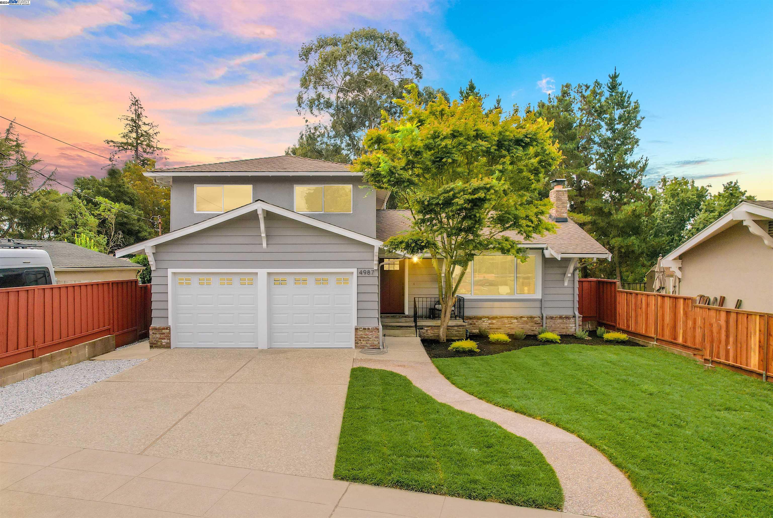 a front view of a house with a yard and trees