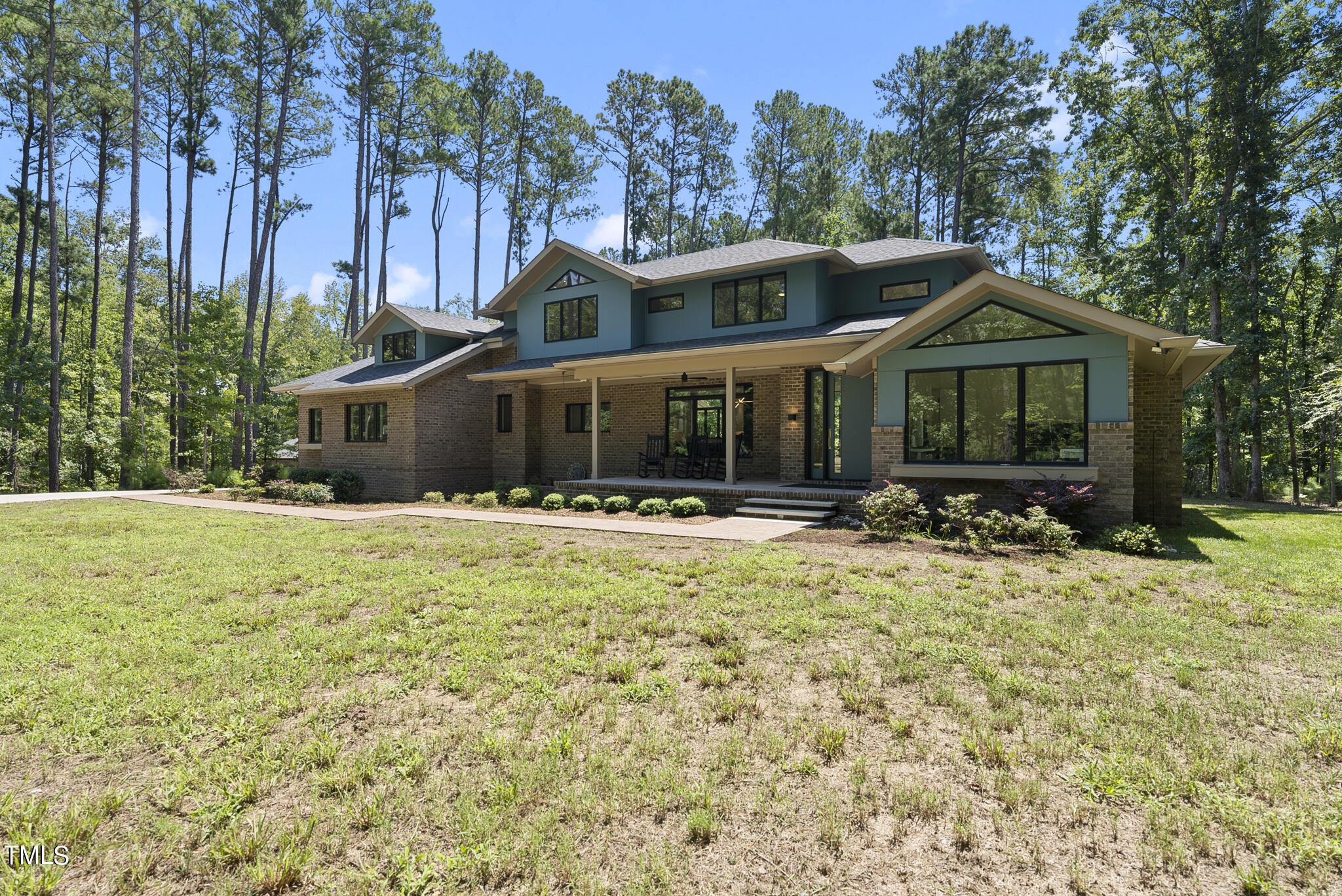 a front view of a house with yard and green space