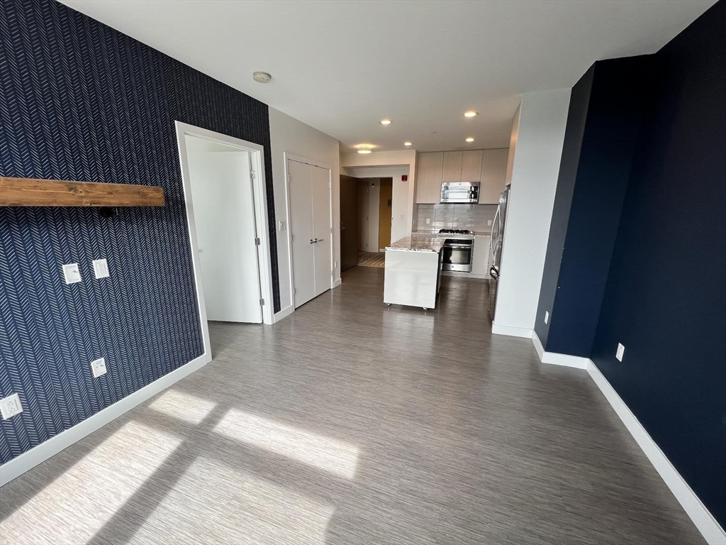 a view of kitchen with stainless steel appliances granite countertop wooden floor a refrigerator and a sink