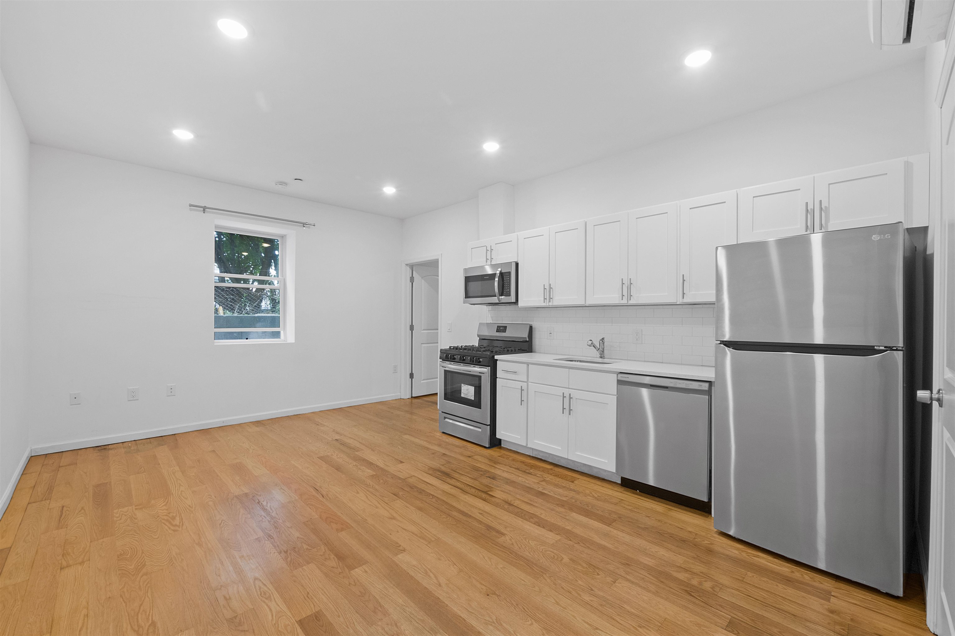 a kitchen with refrigerator cabinets and wooden floor