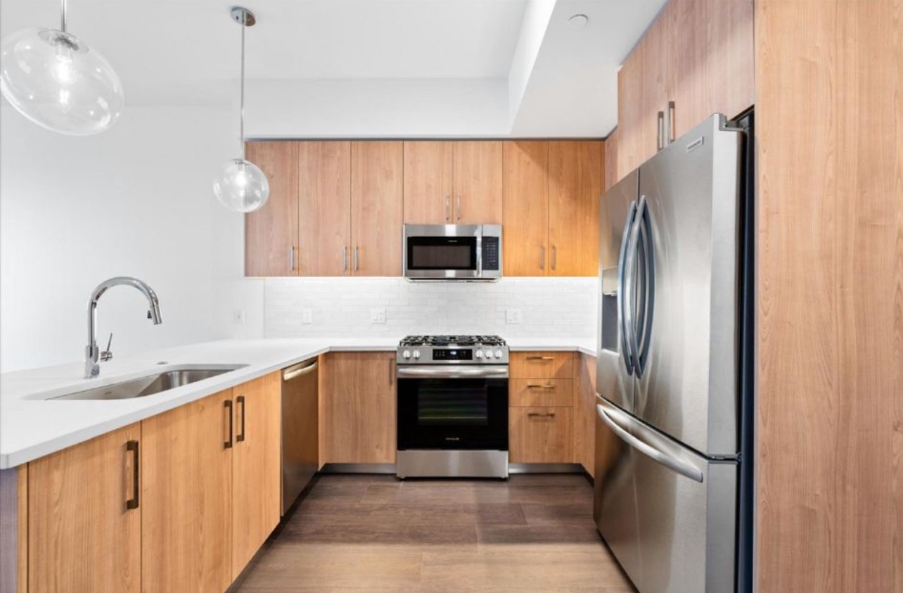 a kitchen with stainless steel appliances granite countertop a refrigerator sink and stove