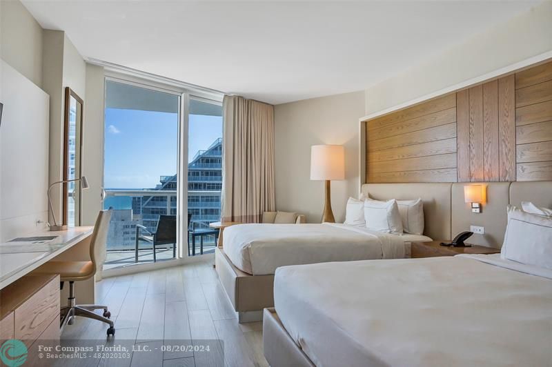 a large bedroom with bed and wooden floor