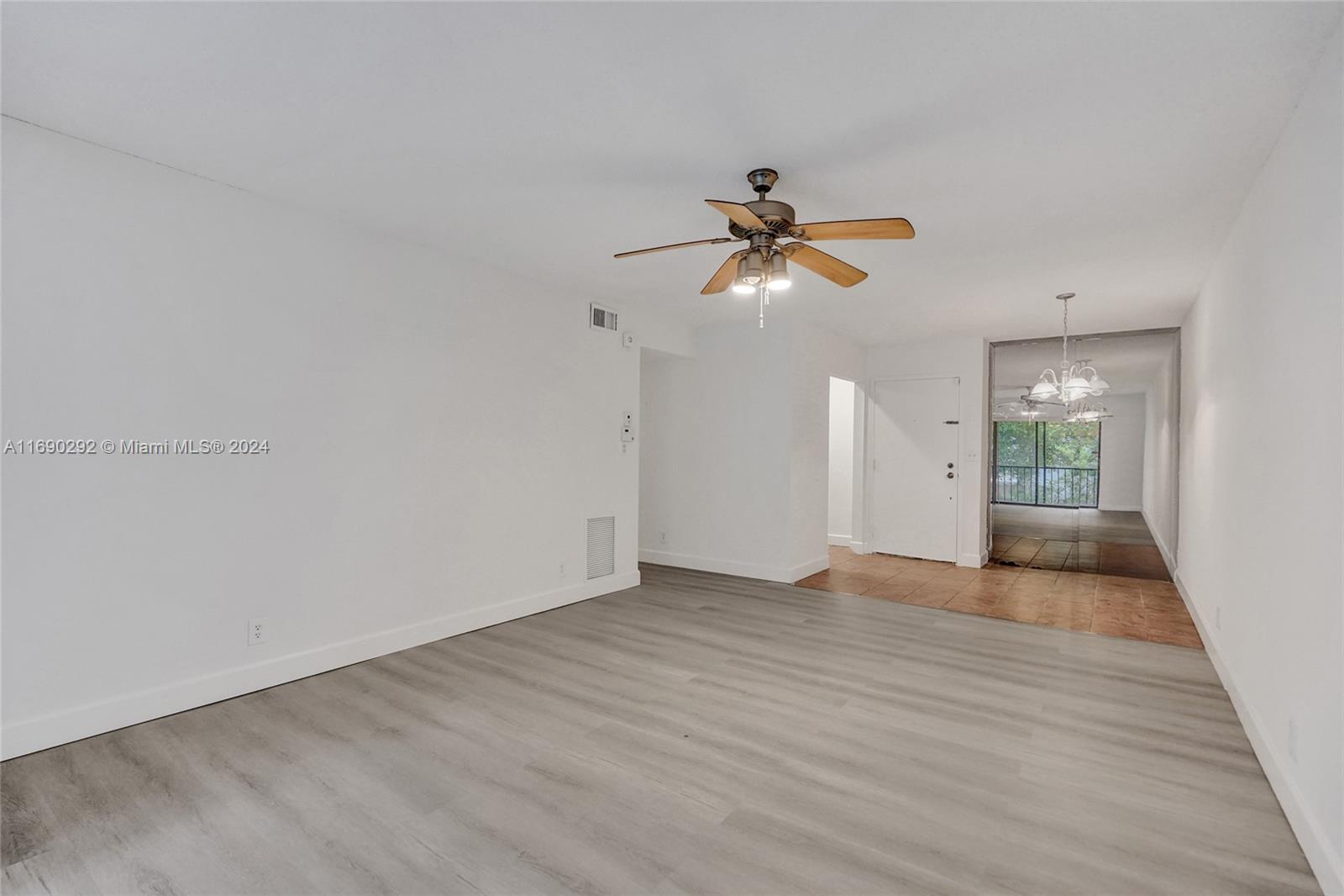 a view of empty room with wooden floor