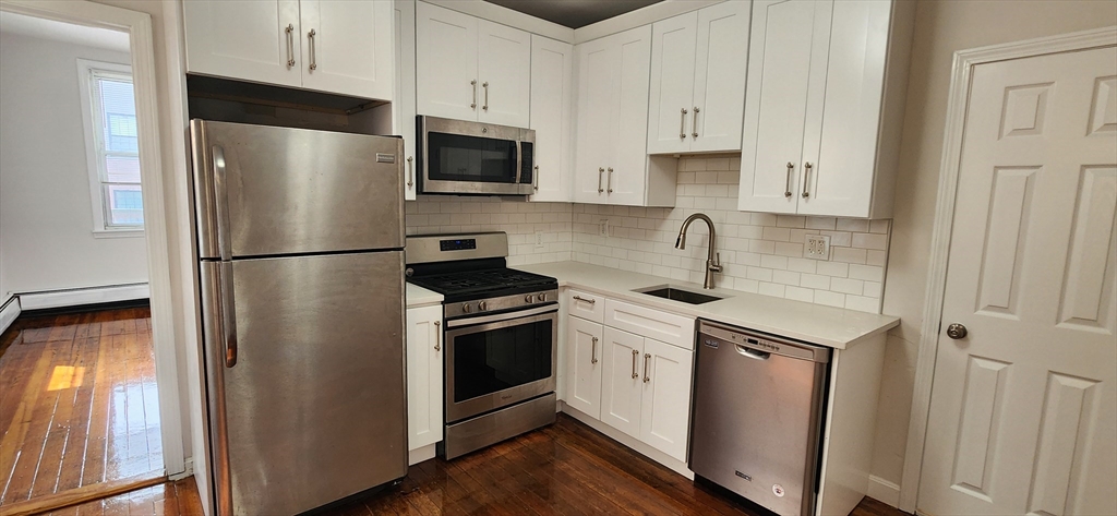 a kitchen with stainless steel appliances granite countertop a refrigerator sink and microwave