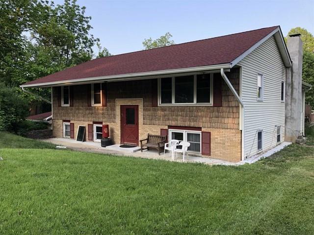 Back of house with a patio area and a yard