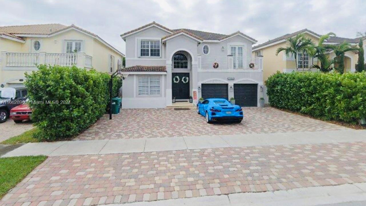 a front view of a house with a yard and a garden