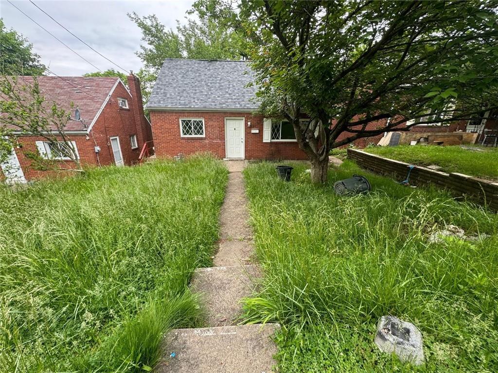 a view of a house with a yard and a tree