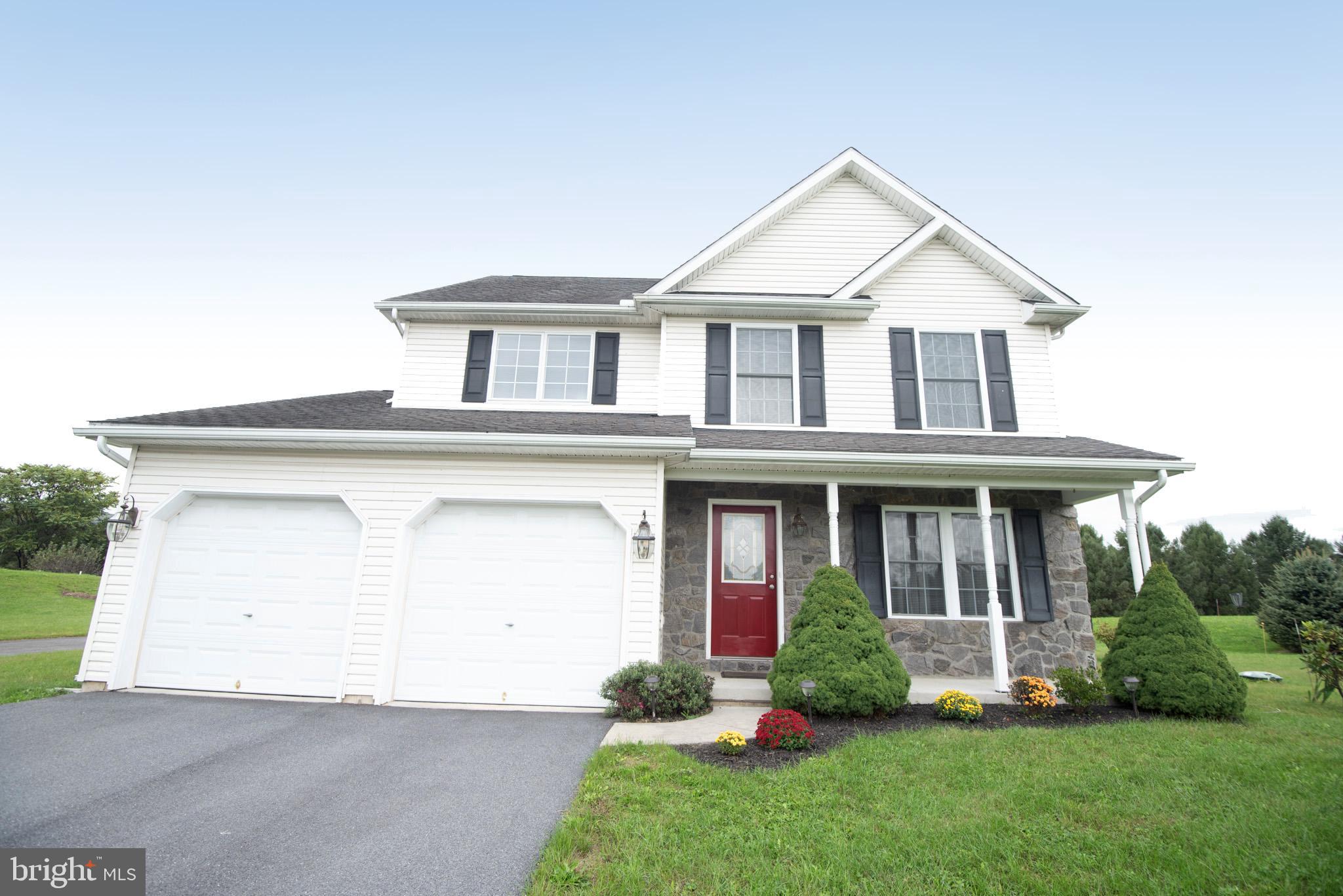 a front view of a house with a yard and plants