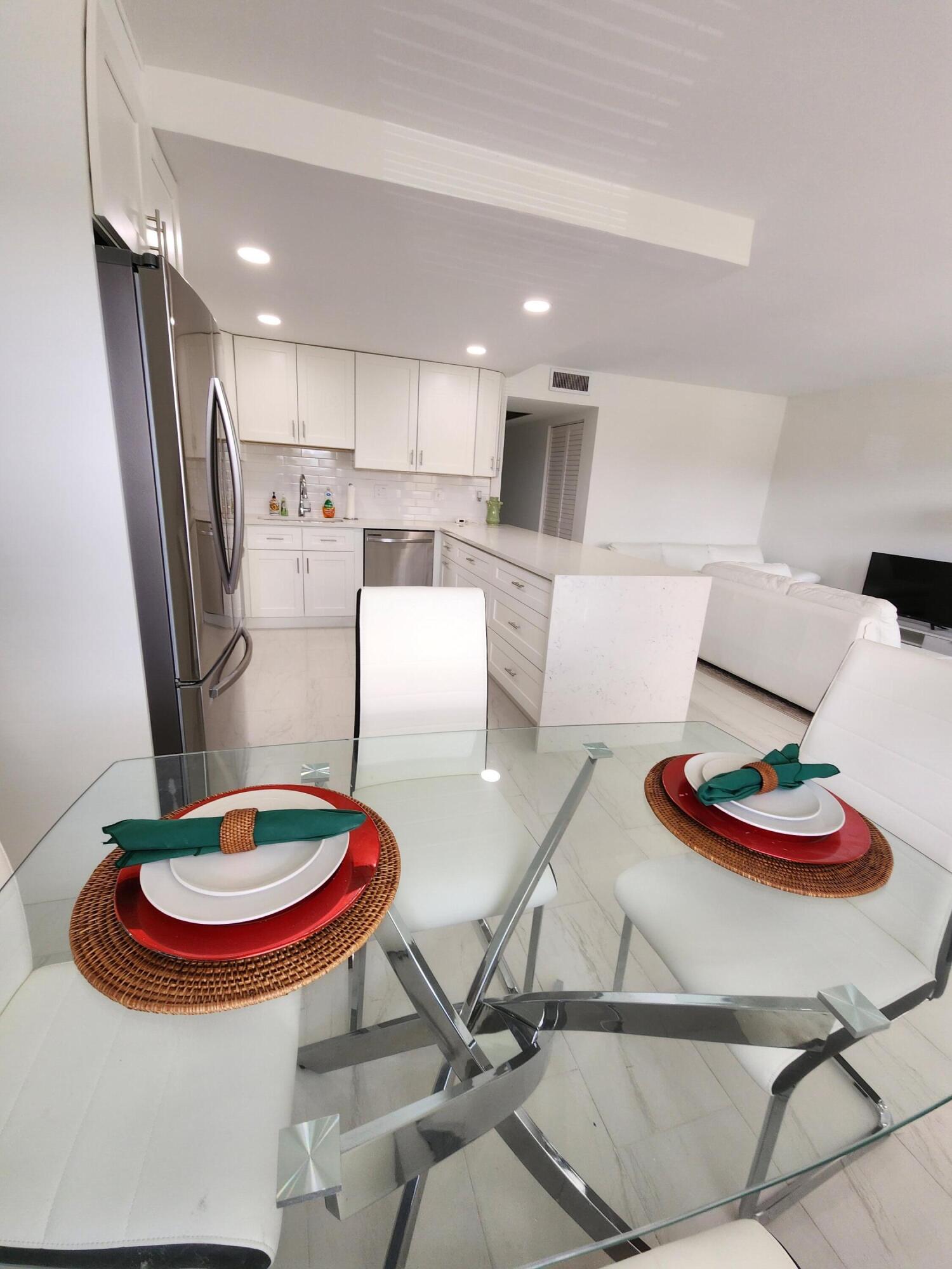 a kitchen with stainless steel appliances granite countertop a sink and a dining table