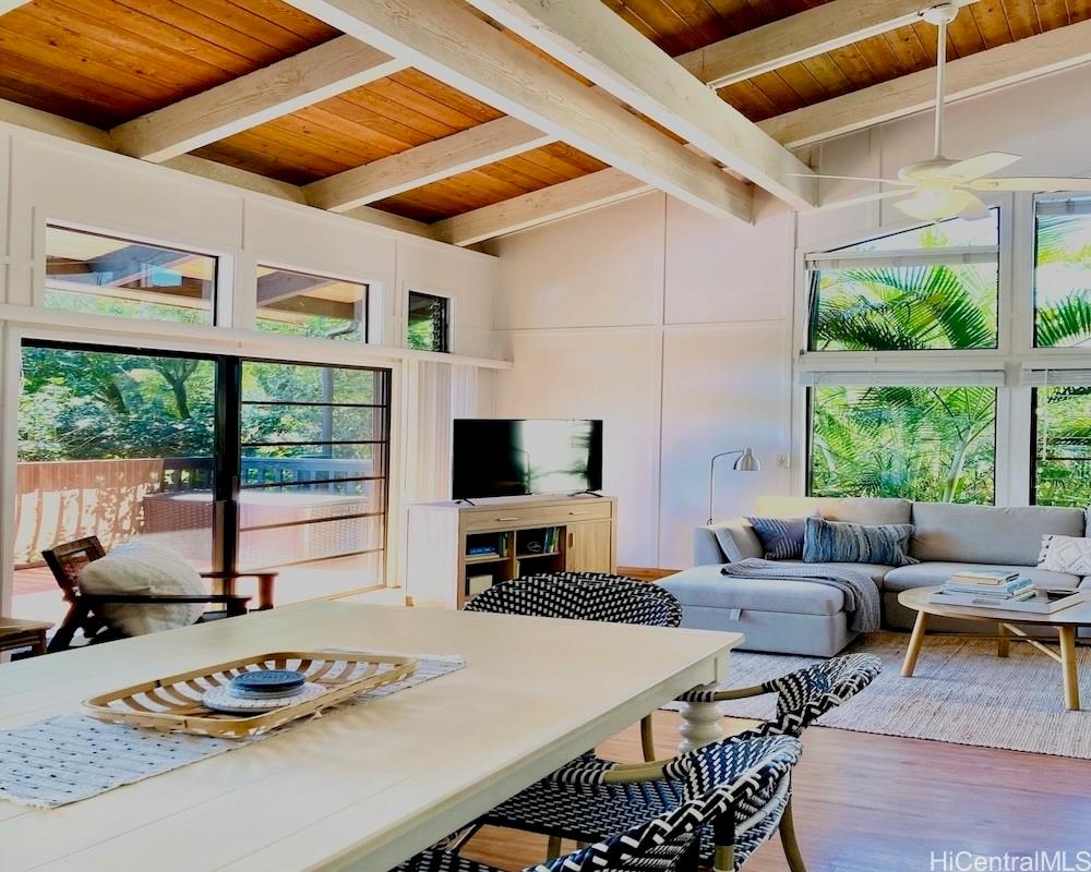 a living room with furniture a flat screen tv and a large window