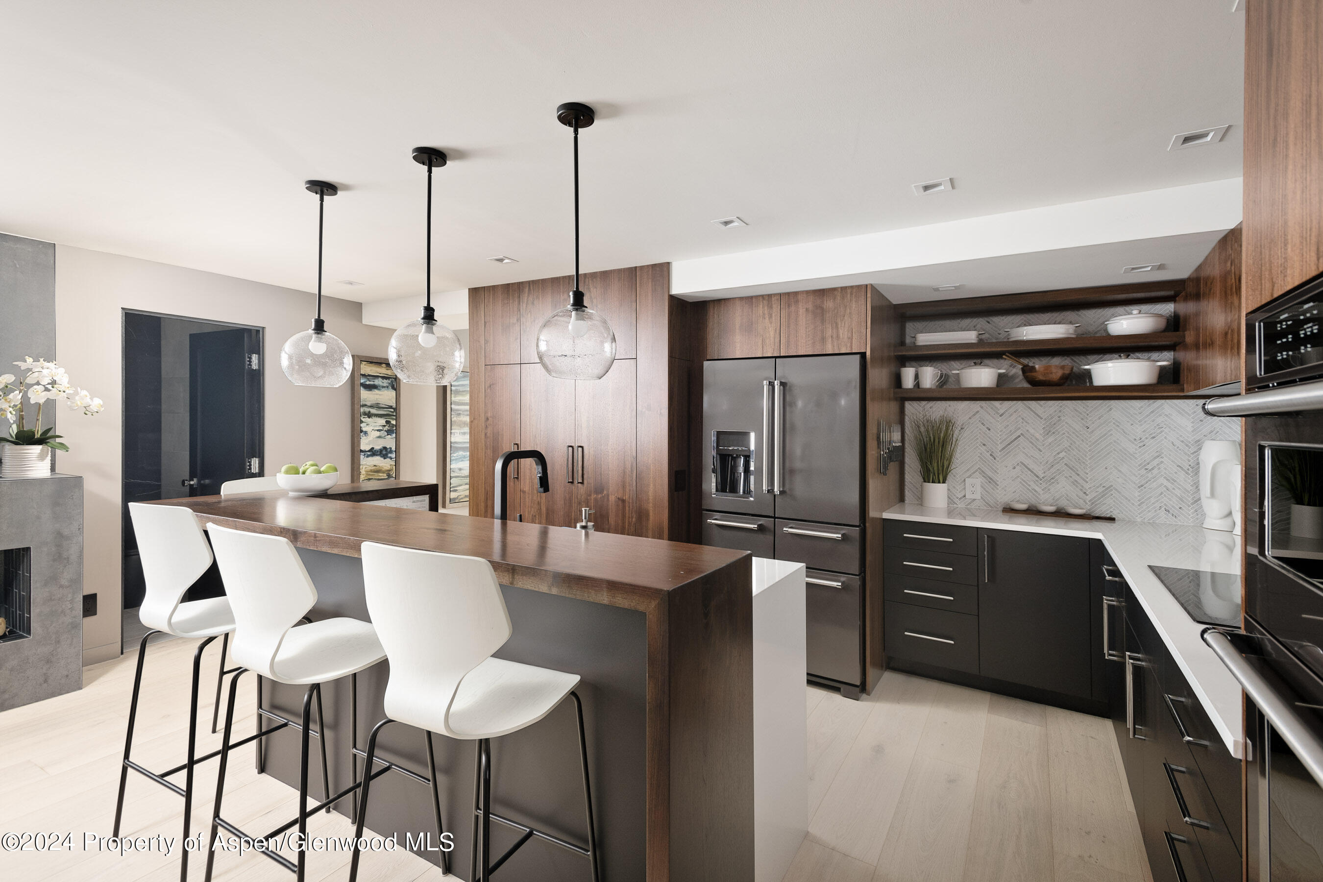 a kitchen with refrigerator and chairs