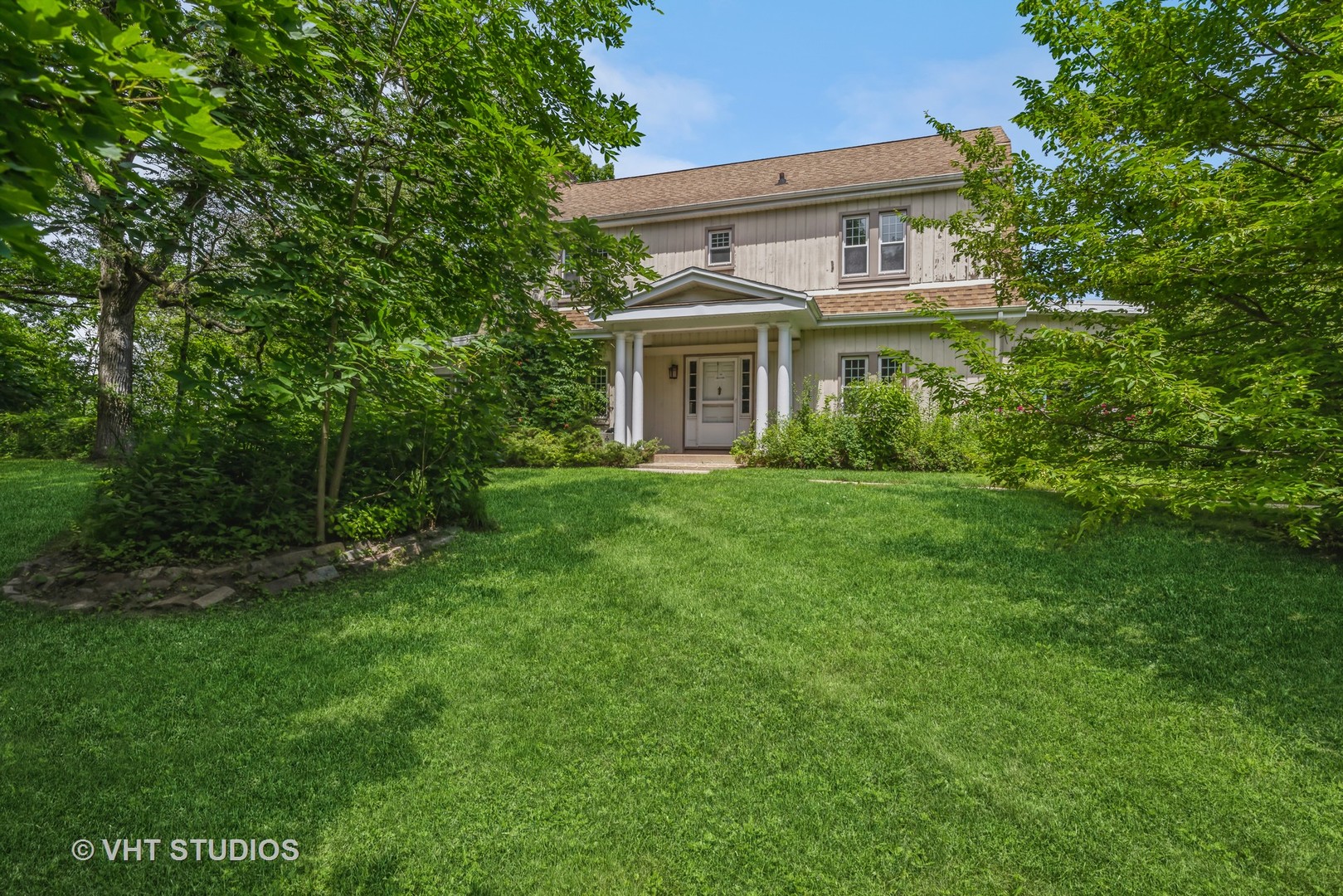 a house that has a big yard with large trees