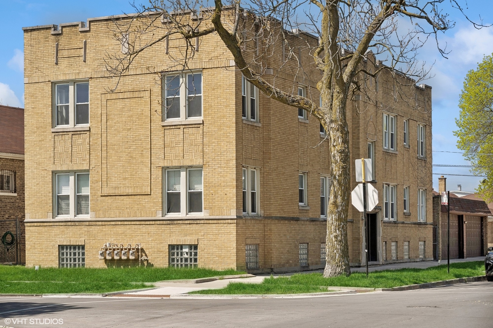 a view of a brick house next to a yard