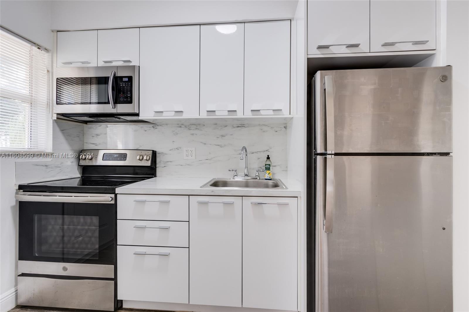 a kitchen with stainless steel appliances white cabinets and a refrigerator