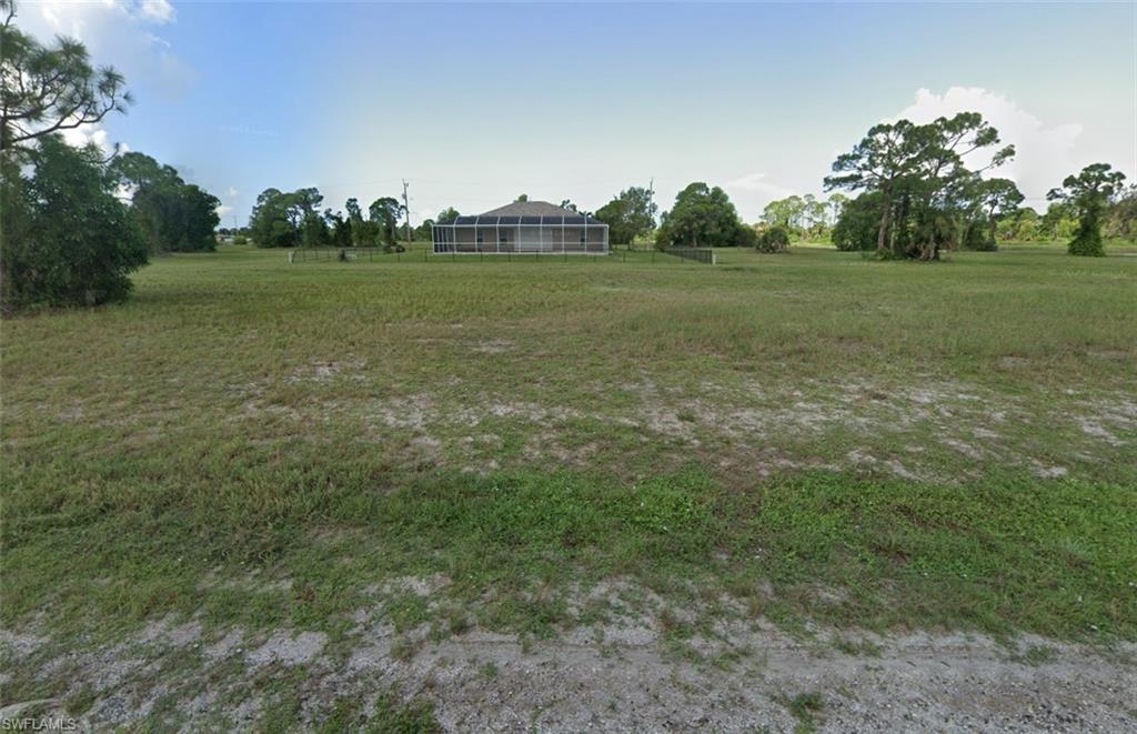 a view of a field with trees in the background