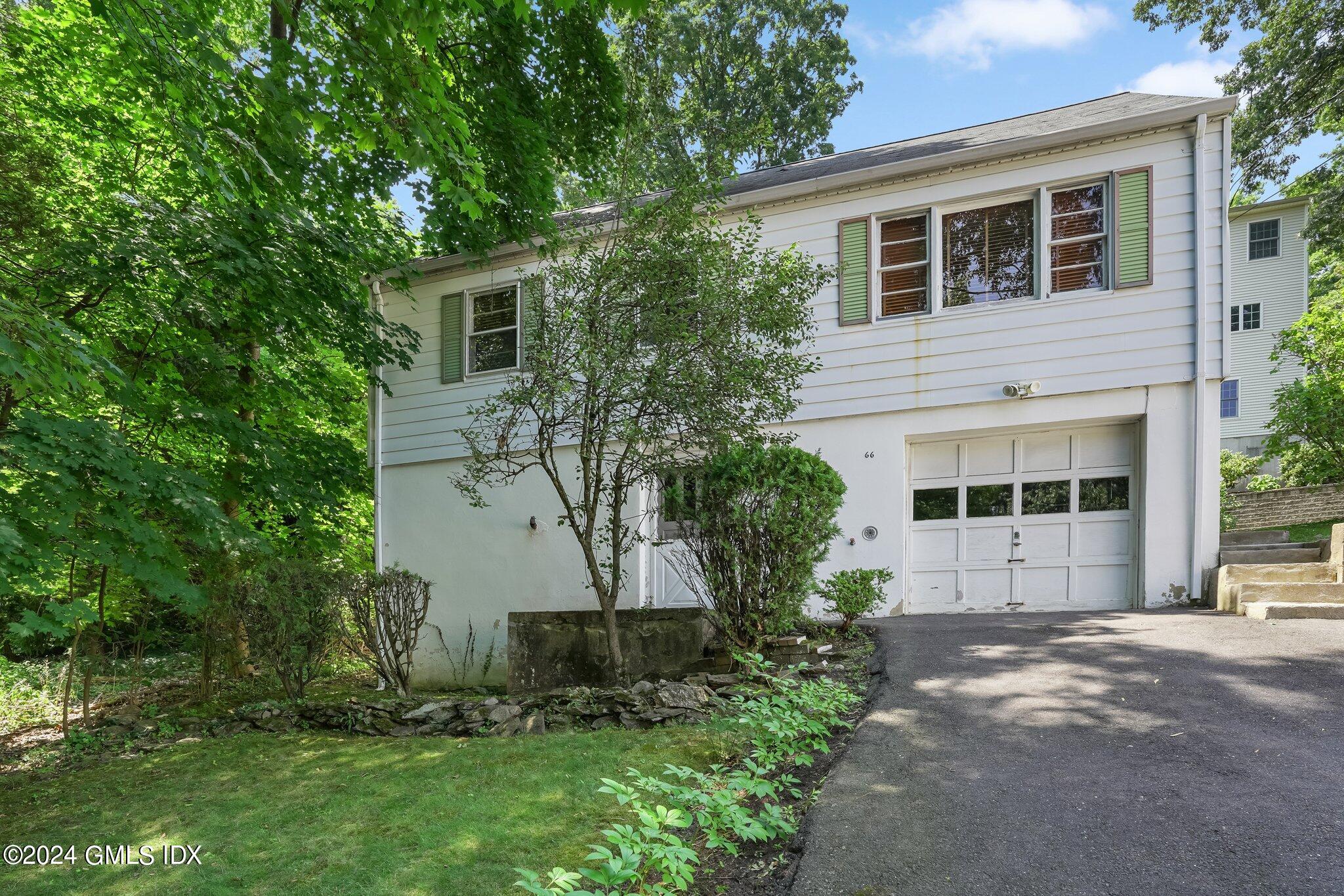 a front view of a house with a yard and trees