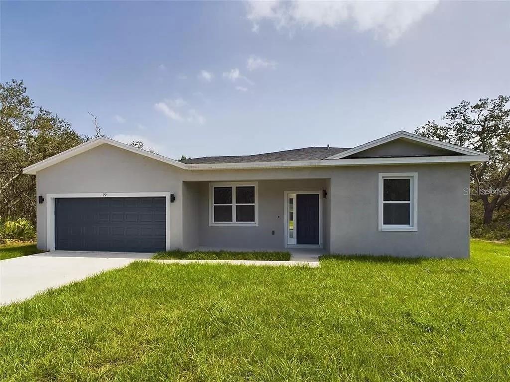 a front view of house with yard and garage