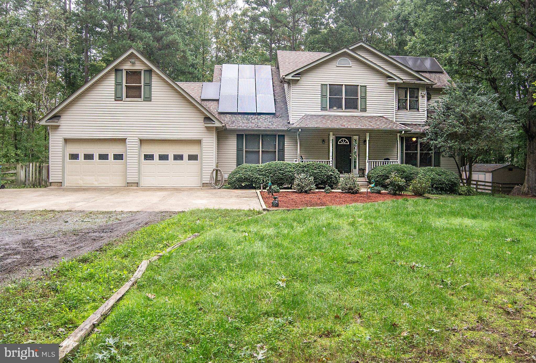 a front view of a house with a yard and green space