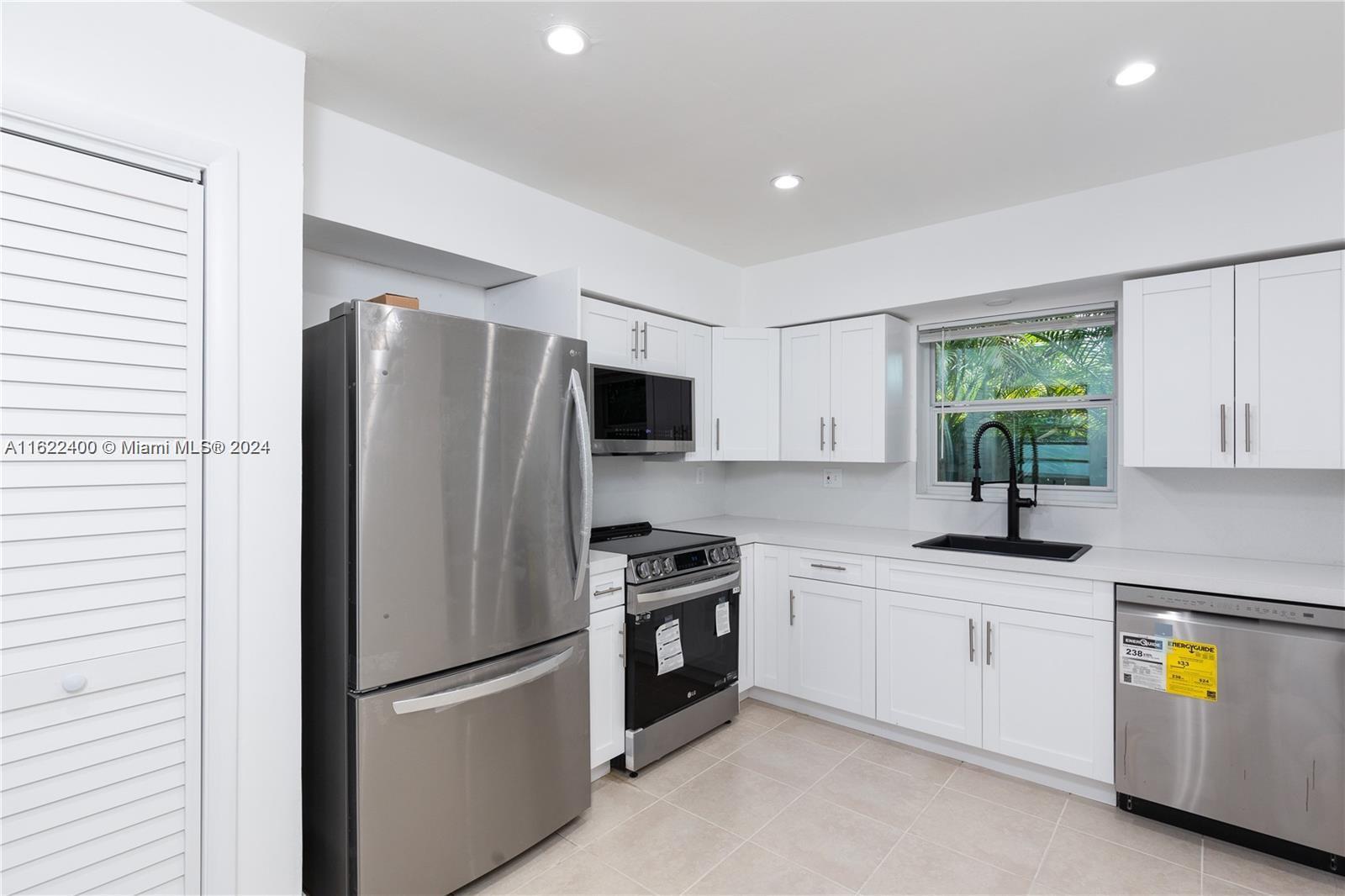 a kitchen with granite countertop a refrigerator and a sink