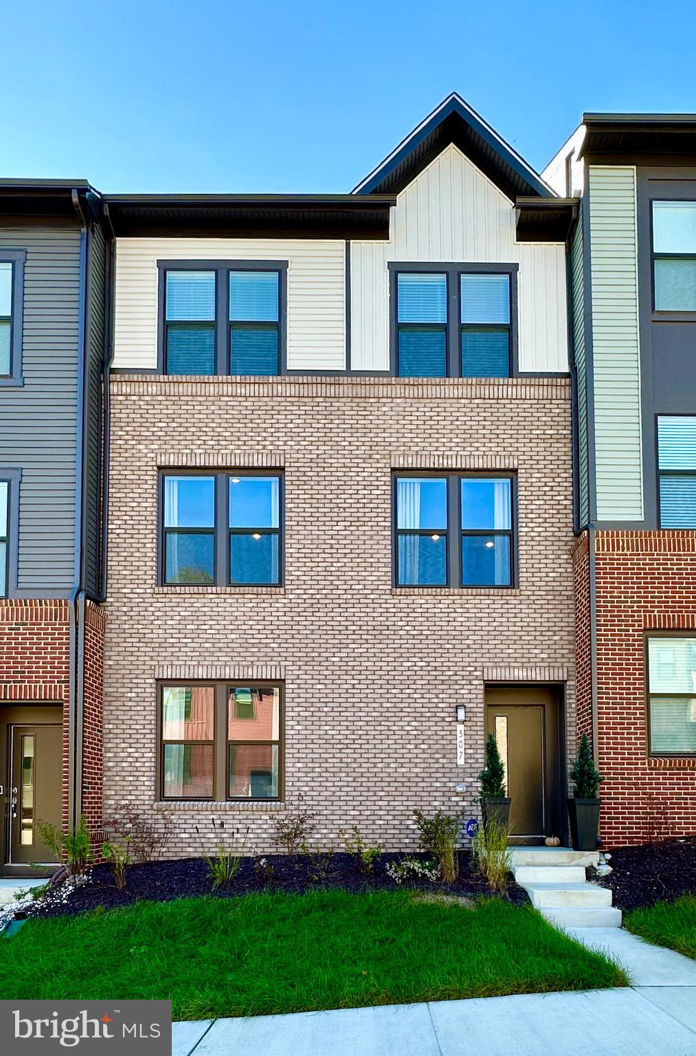 a front view of a house with a yard and outdoor seating