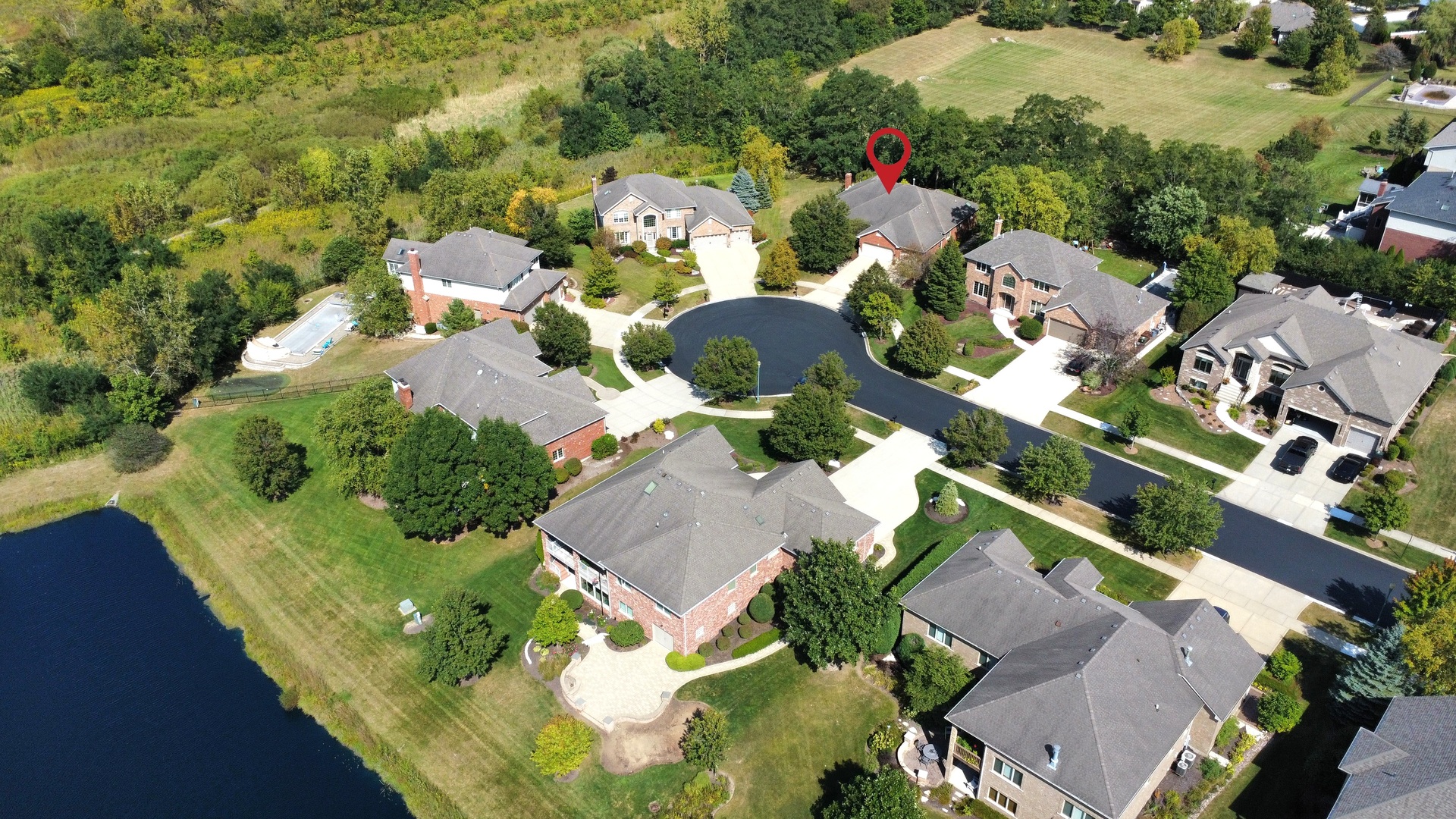 an aerial view of a house with a yard and lake view