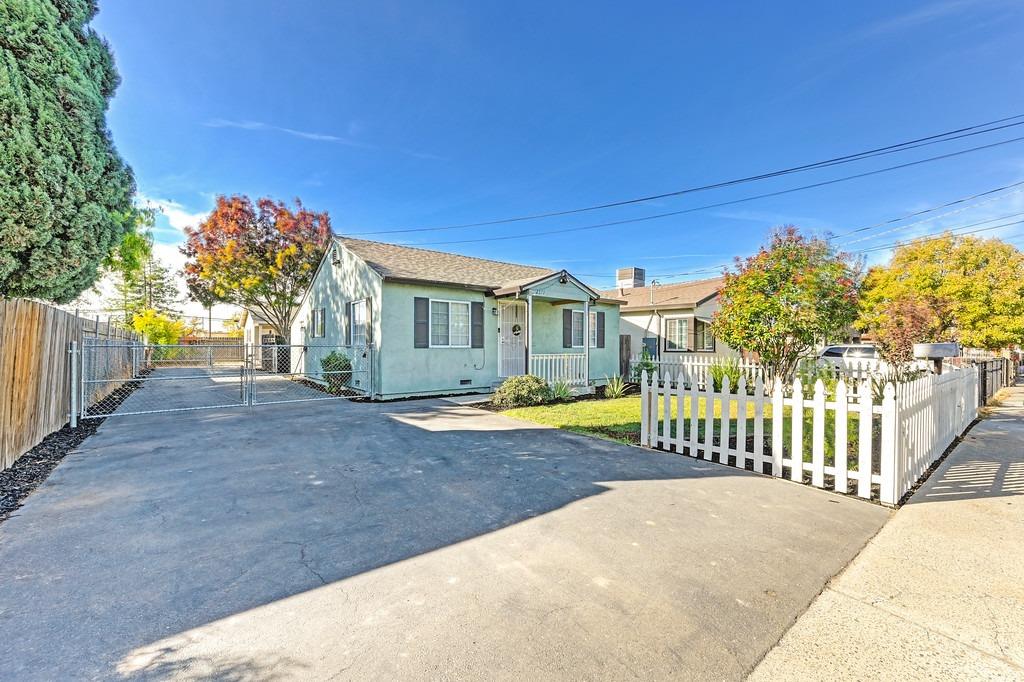 a view of a house with backyard and a tree