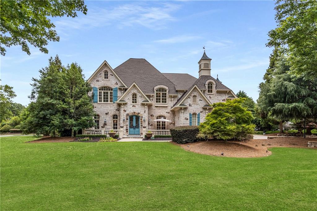 a front view of a house with a garden and trees