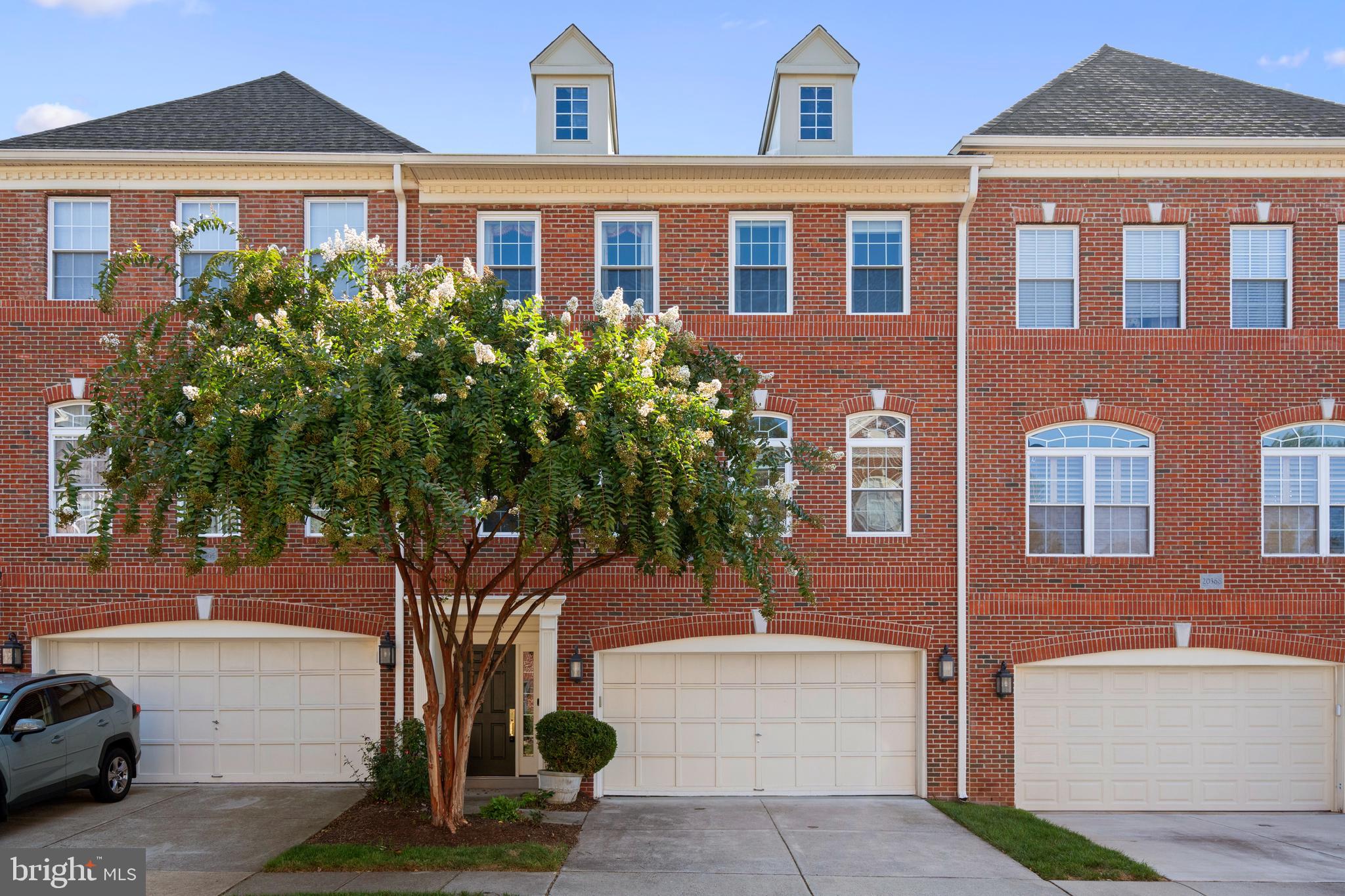 a front view of a house with yard and parking