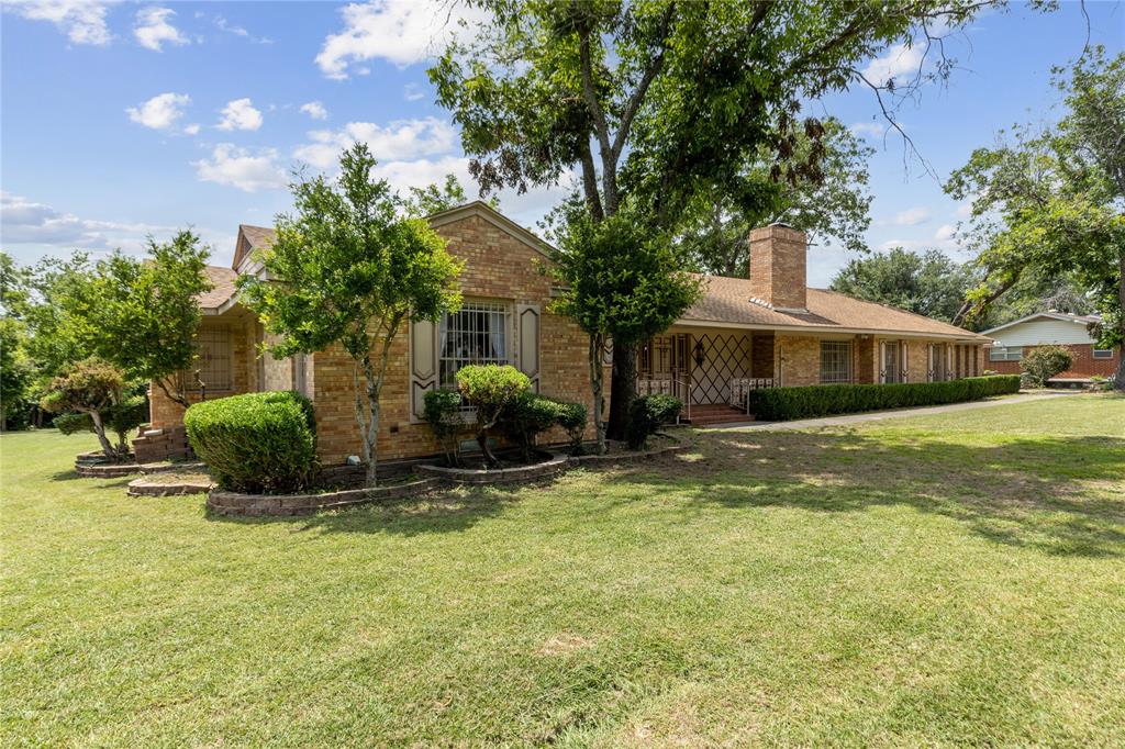 a view of a house with a yard and tree s