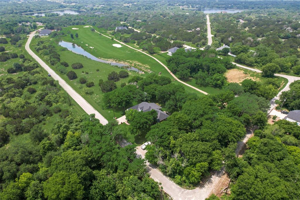 an aerial view of a residential houses with outdoor space and trees