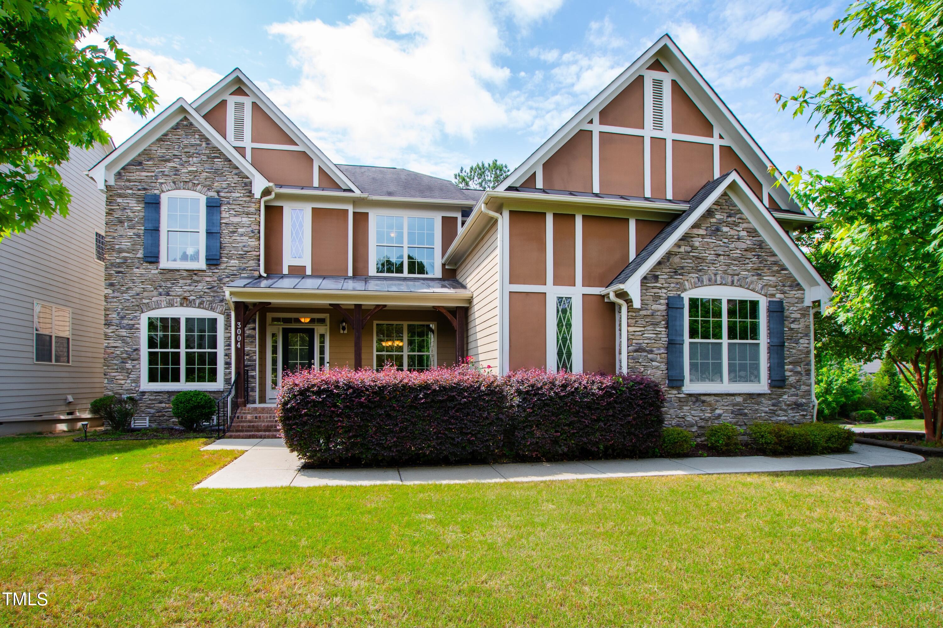 a front view of a house with a yard and potted plants