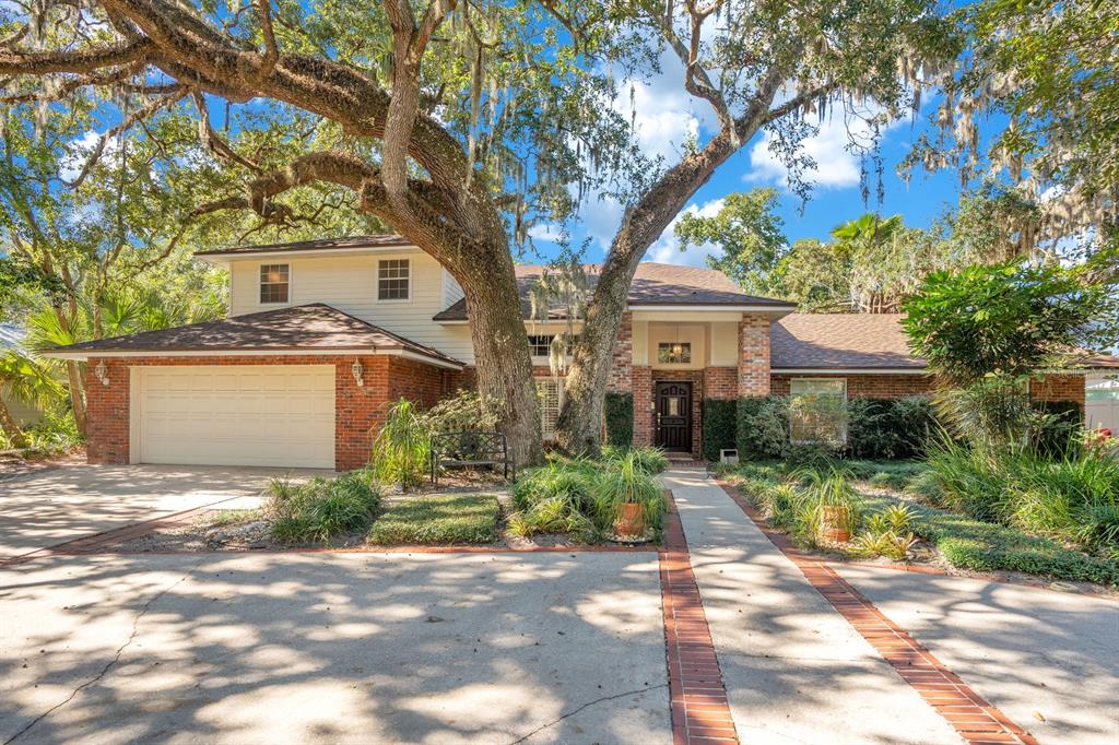 a front view of a house with a yard and trees