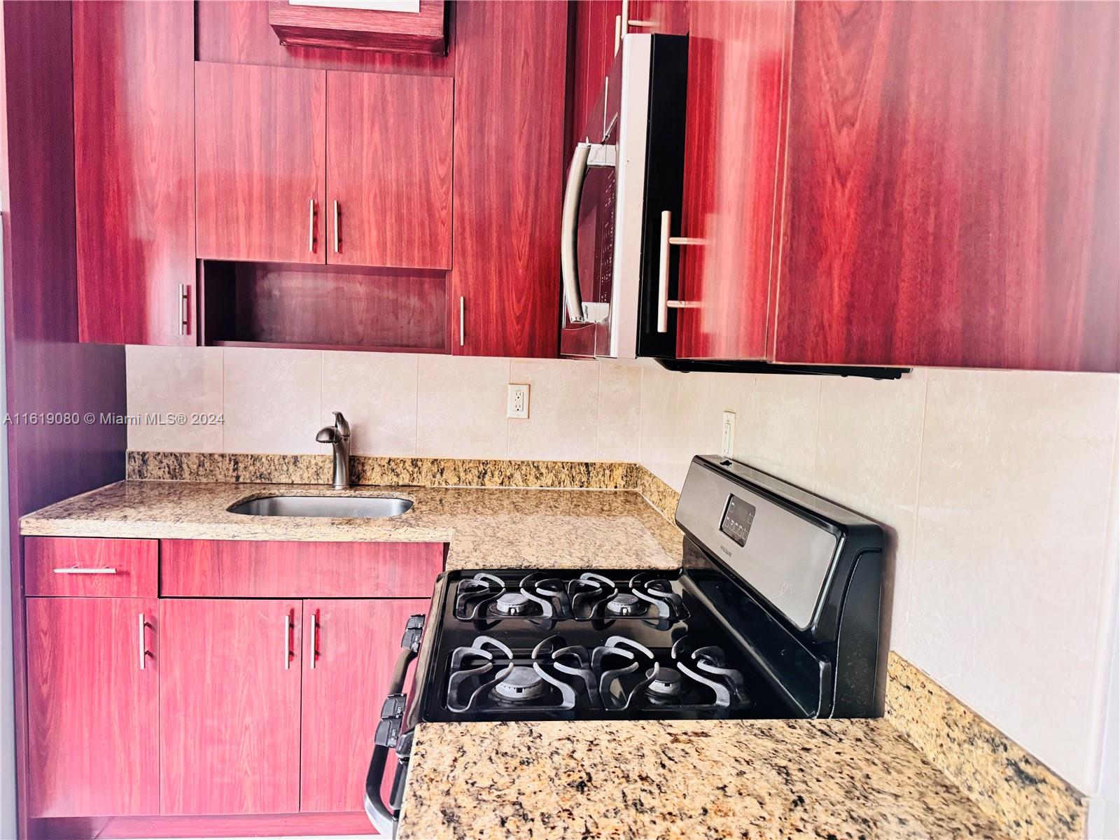 a kitchen with granite countertop a stove and a sink