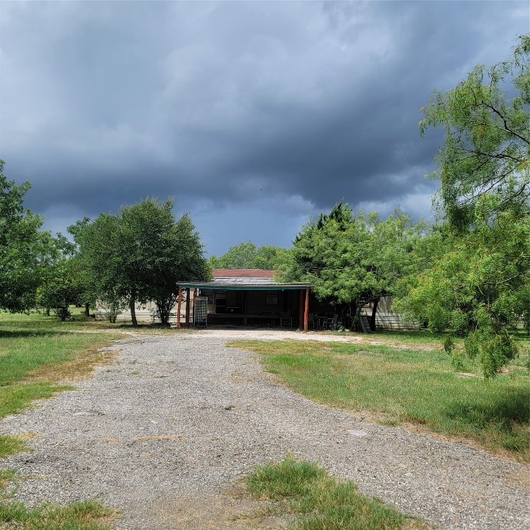 a front view of a house with a yard and trees