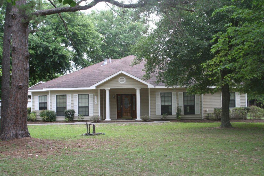 a front view of a house with a yard and trees