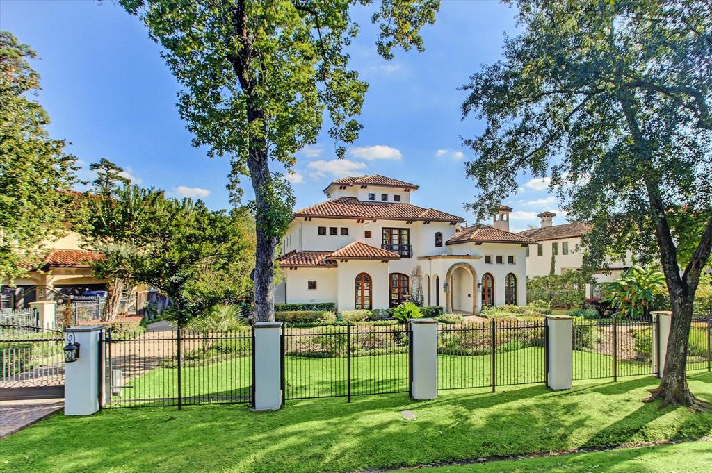 a view of a white house with a big yard and large trees