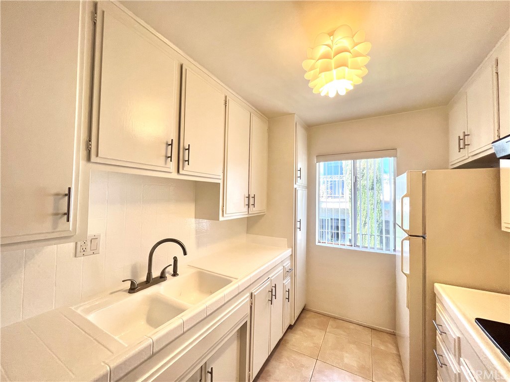 a view of a kitchen with stainless steel appliances granite countertop a sink and a refrigerator