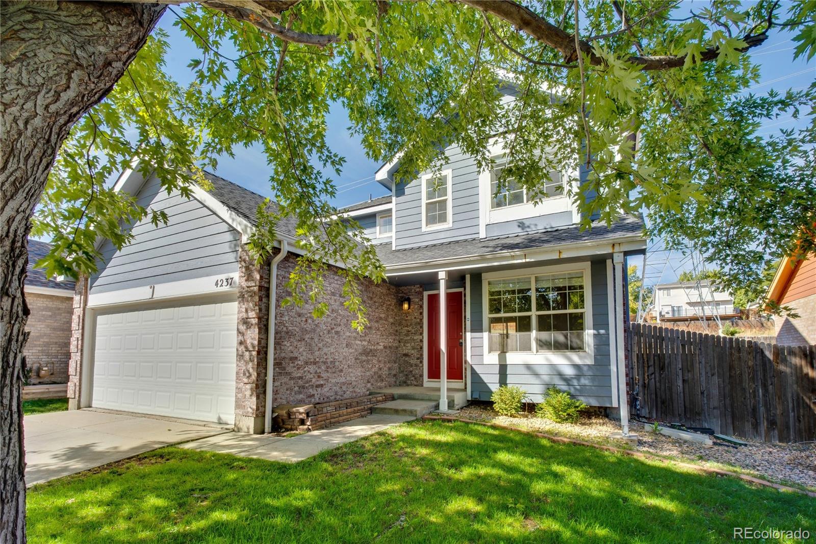 a view of a house with a yard and tree