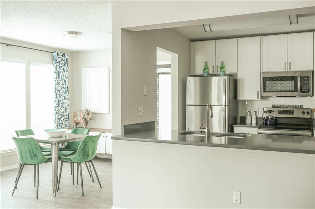 a kitchen with stainless steel appliances a refrigerator and a table