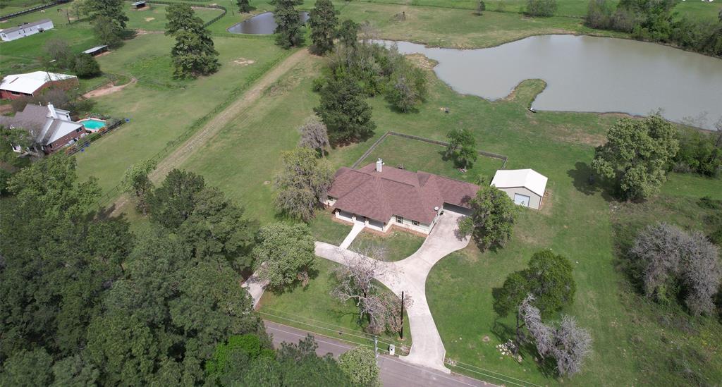 an aerial view of a house with a garden and lake view