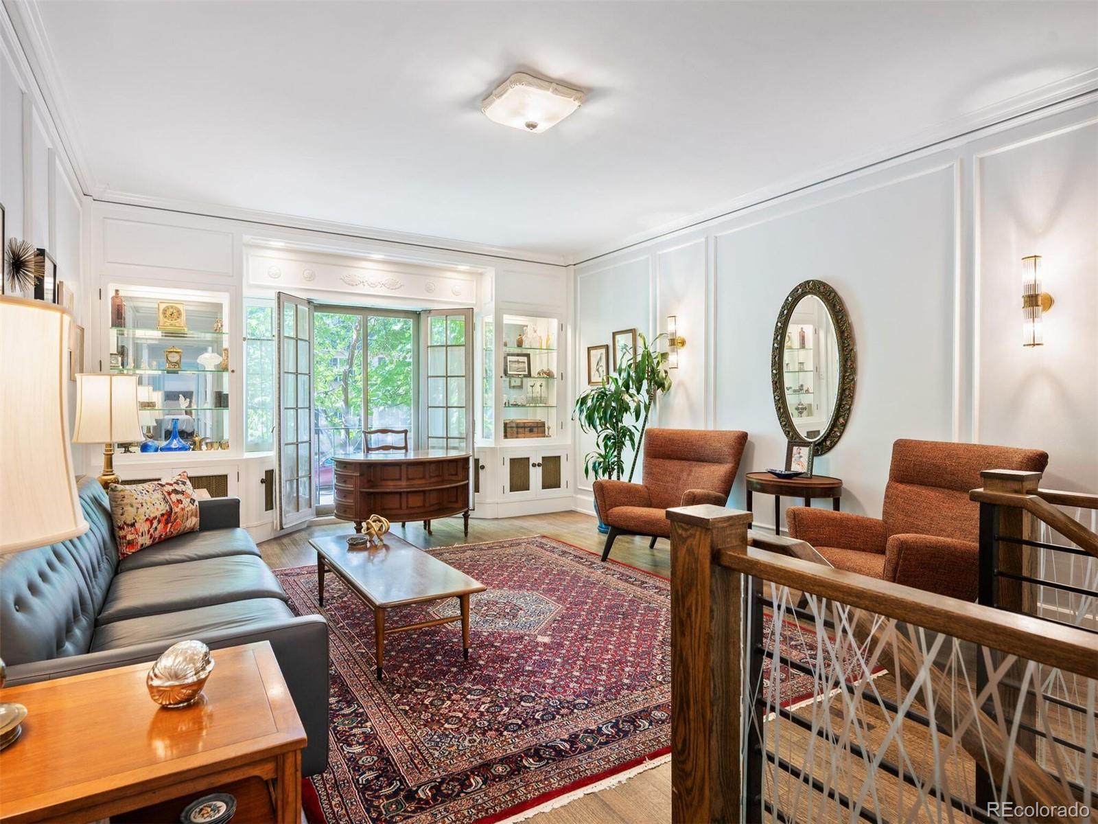 a living room with furniture a rug and a floor to ceiling window