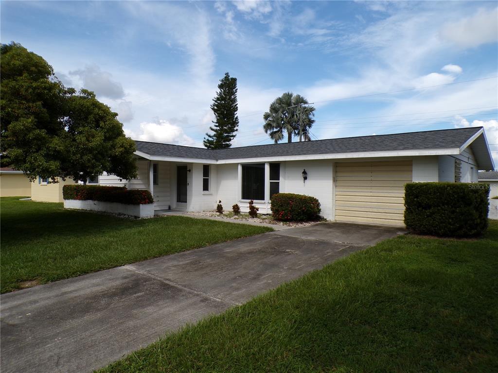 a front view of a house with a yard and trees